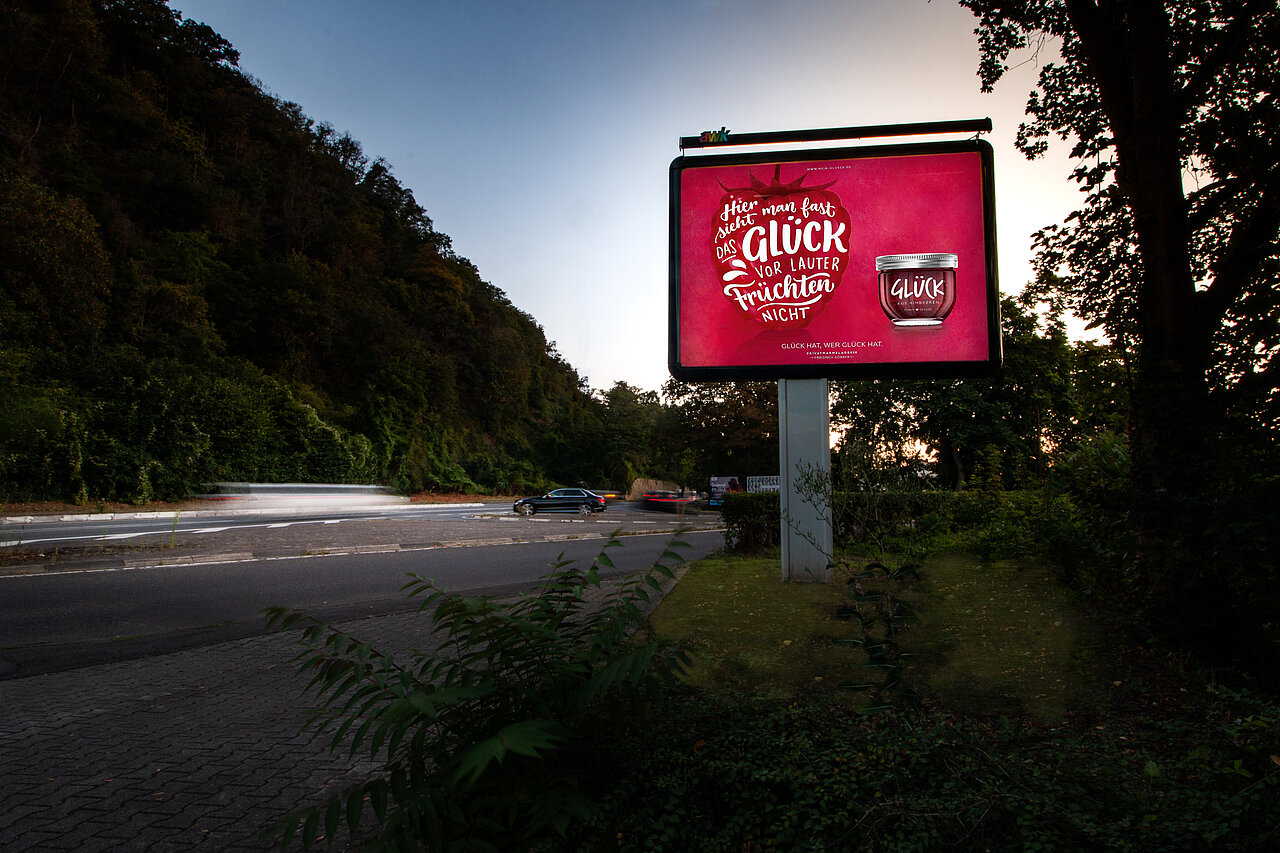 Citystar an befahrener Straße am Waldrand mit Motiv von Glück
