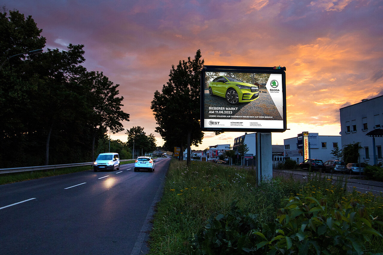 Großfläche am Straßenrand mit Plakatmotiv, das für Autohaus wirbt