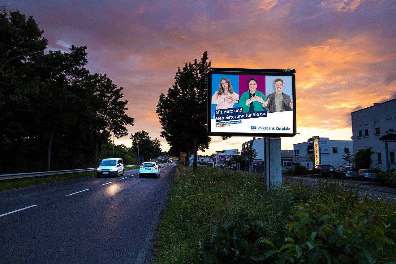 Großplakat mit 9 qm Werbefläche steht an befahrener Straße mit Volksbank-Motiv